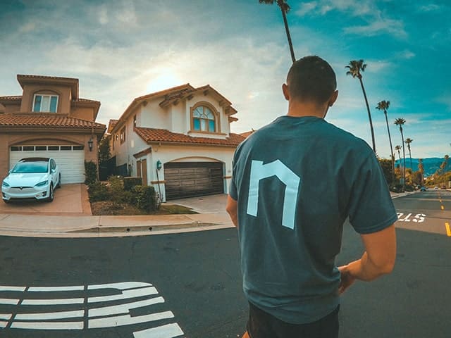 Next Moving house movers near me is going toward the client's two story house with the Next Moving logo on his t-shirt.