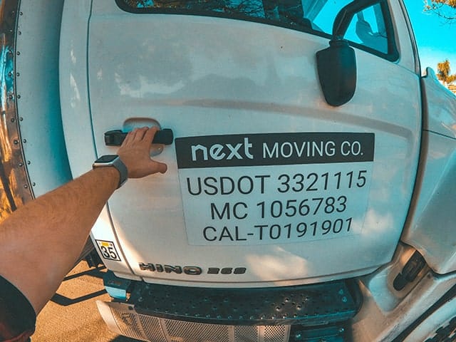 Next Moving professional furniture movers near me is opening moving trucks door with USDOT, MC and CAL-T number on it ready to provide furniture delivery service and cargo delivery