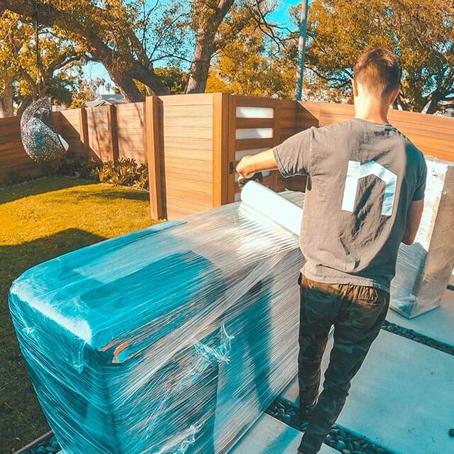 Next Moving mover near me demonstrates his packing hacks and tricks wrapping the couch.