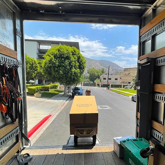 Next Moving local Burbank CA mover moving the wardrobe box into the Next Moving truck during the moving process in Burbank, California.