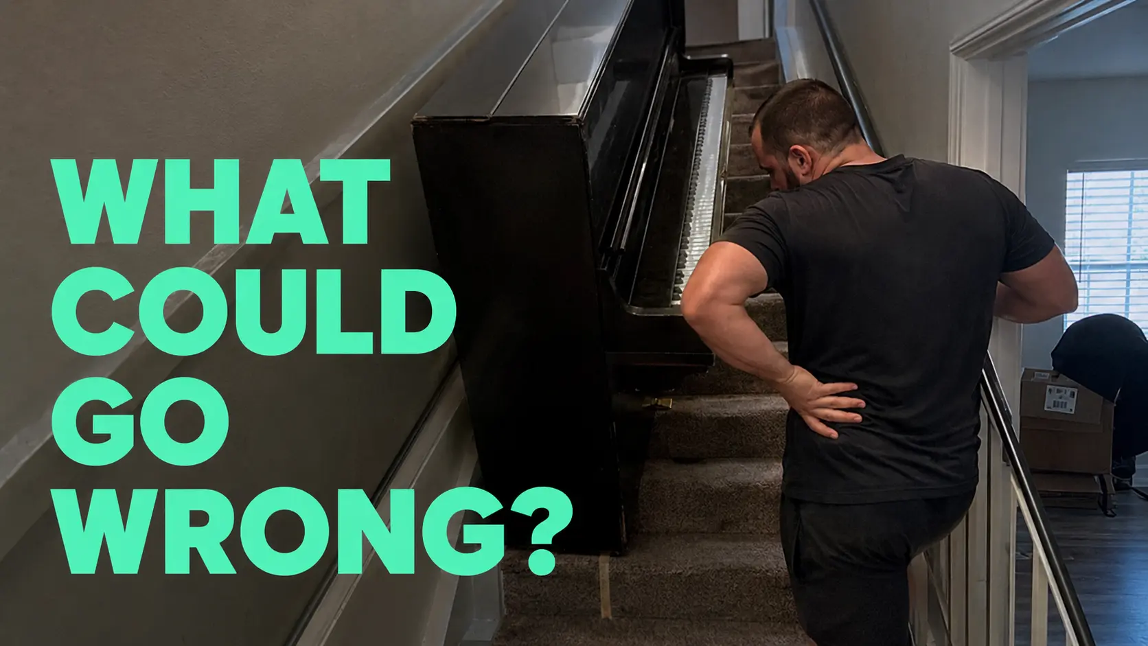 Man holding his back beside an upright piano on stairs - DIY piano moving risks