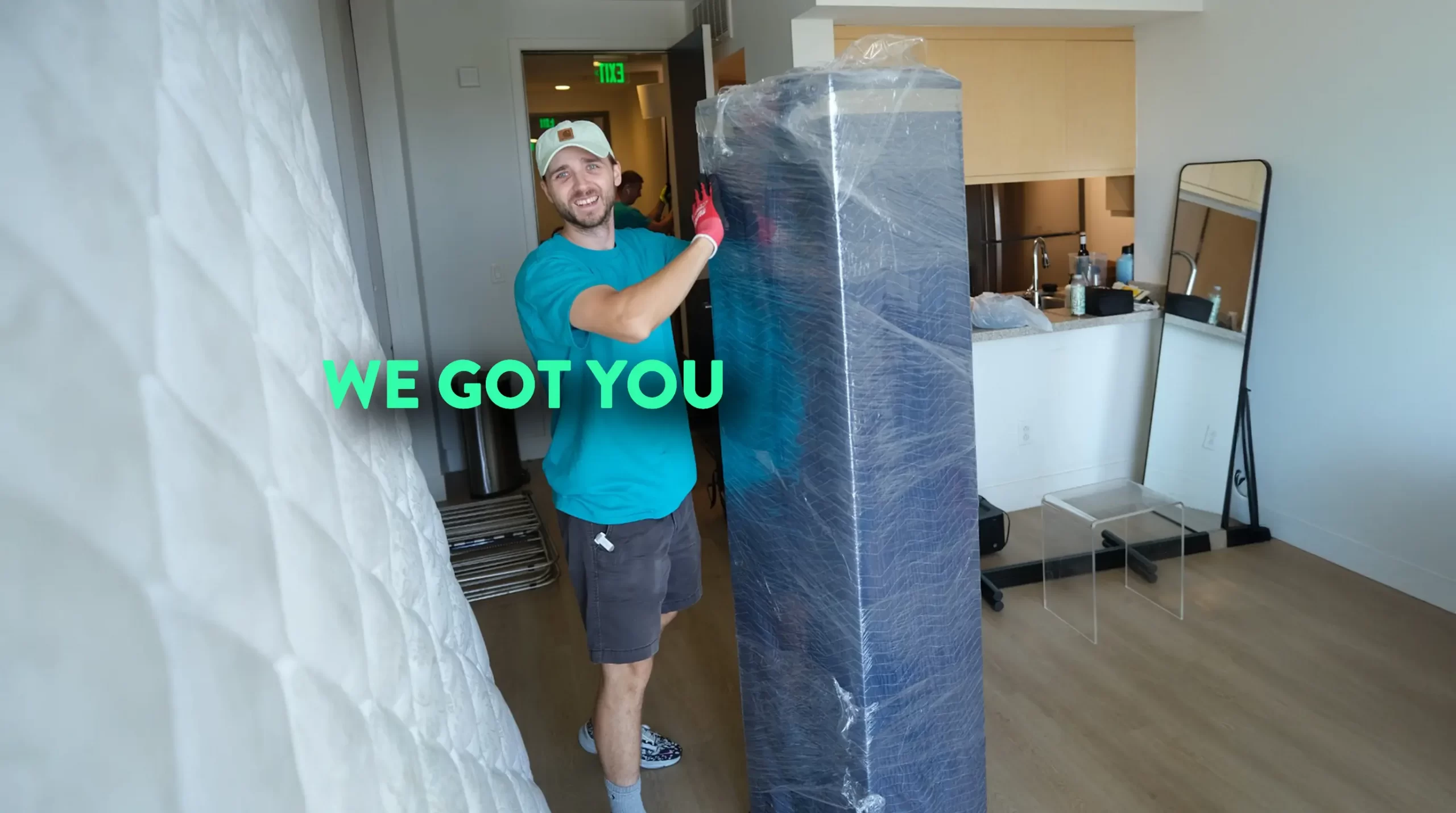 Smiling Next Moving mover carrying a wrapped mattress - when to call movers